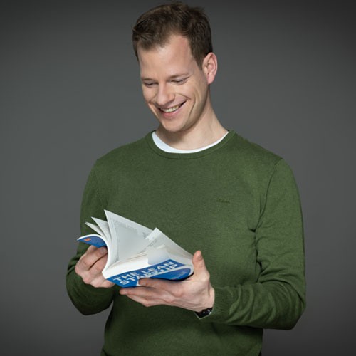 IT Recruiting Portrait of Jürgen with book (Manager Software Development Simulation).